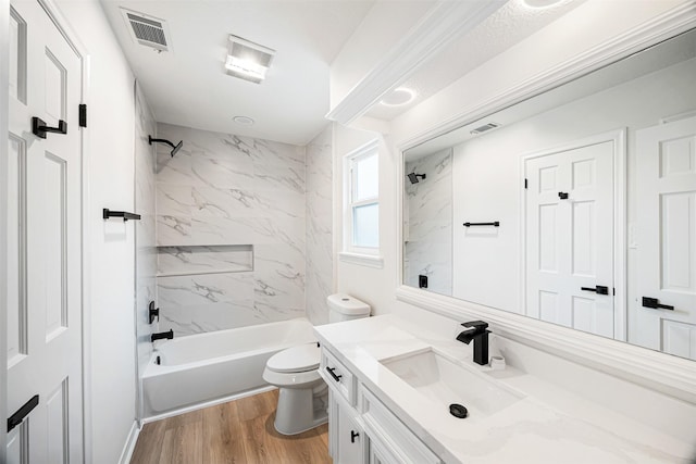 full bathroom featuring toilet, vanity, tiled shower / bath combo, and hardwood / wood-style flooring