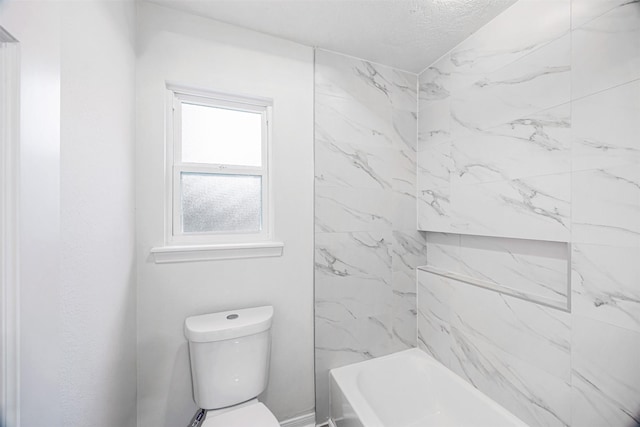 bathroom with tiled shower / bath combo and toilet