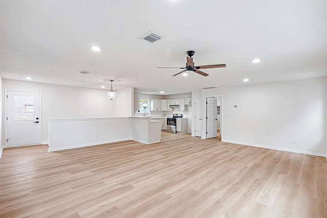 unfurnished living room featuring light wood-type flooring, plenty of natural light, and ceiling fan