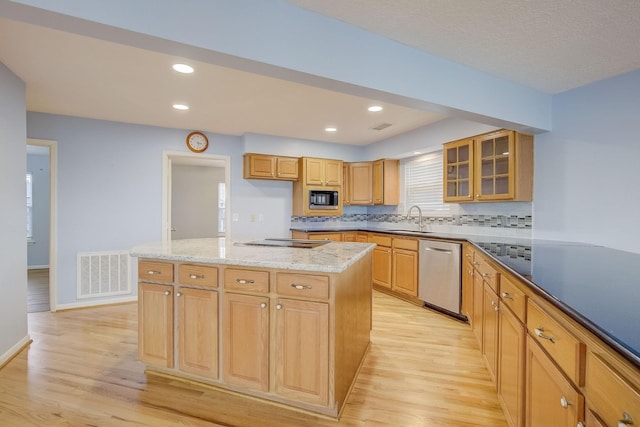 kitchen with sink, light hardwood / wood-style floors, a kitchen island, and stainless steel appliances