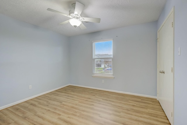 empty room featuring a textured ceiling, light wood-type flooring, and ceiling fan