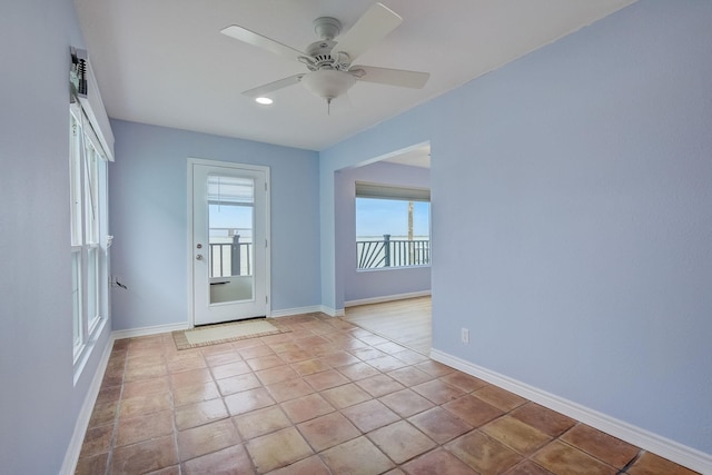 unfurnished room with light tile patterned floors and ceiling fan