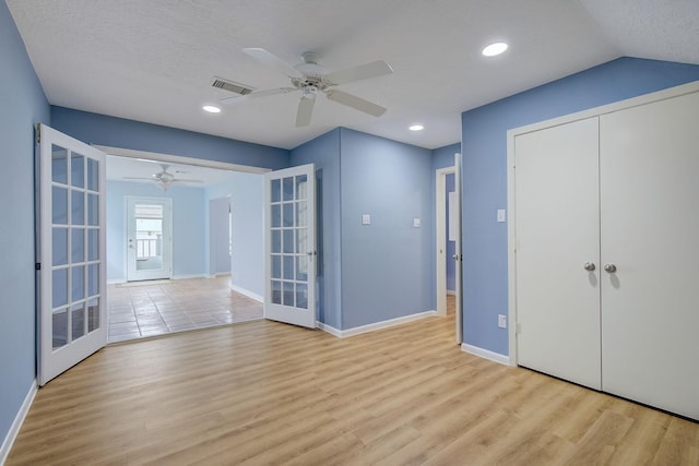 interior space featuring ceiling fan, a closet, light hardwood / wood-style flooring, and french doors