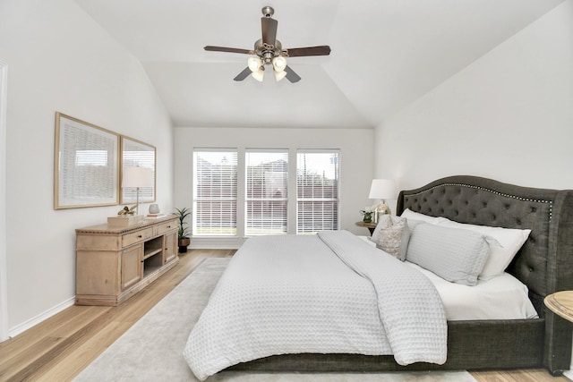 bedroom with ceiling fan, light hardwood / wood-style flooring, and lofted ceiling