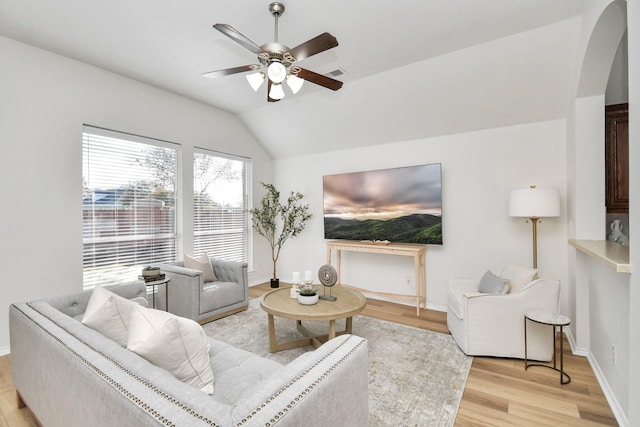 living room with ceiling fan, vaulted ceiling, and light wood-type flooring