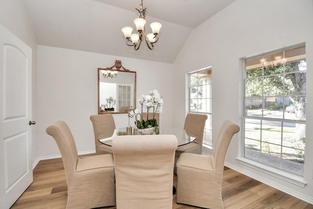 dining space featuring vaulted ceiling, light hardwood / wood-style flooring, and a healthy amount of sunlight