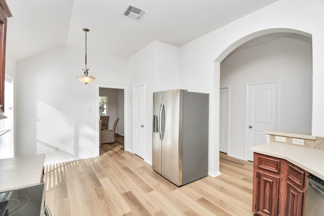 kitchen with pendant lighting, light hardwood / wood-style floors, lofted ceiling, and appliances with stainless steel finishes