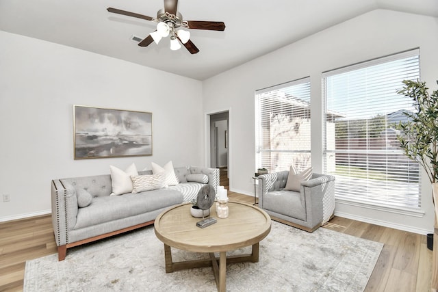 living room with wood-type flooring, a wealth of natural light, lofted ceiling, and ceiling fan