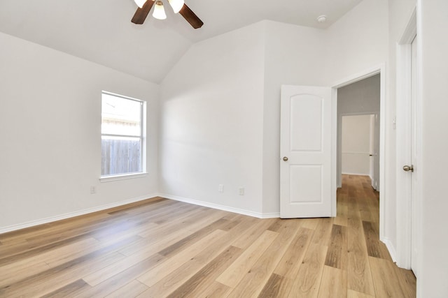 empty room featuring light hardwood / wood-style floors, vaulted ceiling, and ceiling fan