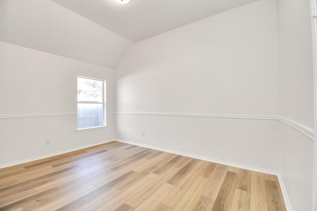 unfurnished room featuring light hardwood / wood-style floors and vaulted ceiling