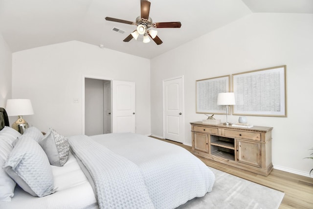 bedroom with ceiling fan, light hardwood / wood-style floors, and vaulted ceiling