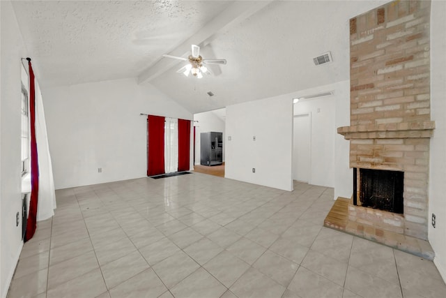 unfurnished living room featuring light tile patterned flooring, vaulted ceiling with beams, ceiling fan, a textured ceiling, and a large fireplace