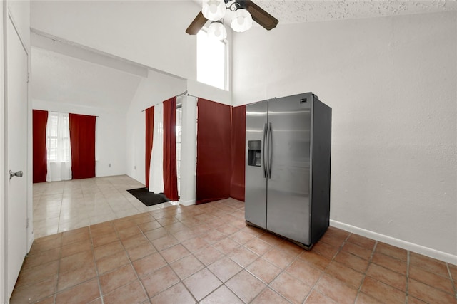 kitchen featuring stainless steel refrigerator with ice dispenser, light tile patterned floors, vaulted ceiling, and ceiling fan