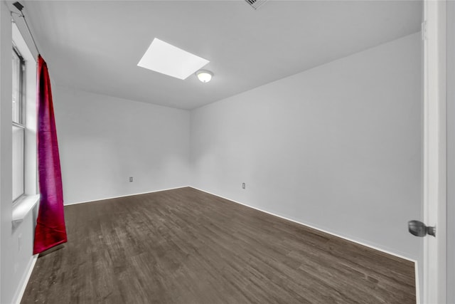 unfurnished room with a skylight and dark wood-type flooring