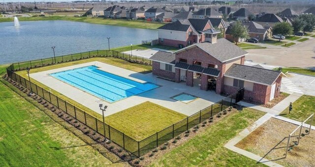 view of swimming pool featuring a water view and a lawn