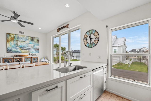 kitchen featuring dishwasher, white cabinets, sink, ceiling fan, and light hardwood / wood-style floors