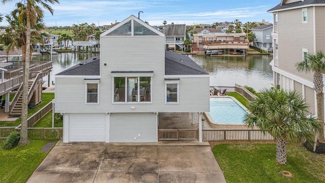 rear view of property with a lawn and a water view