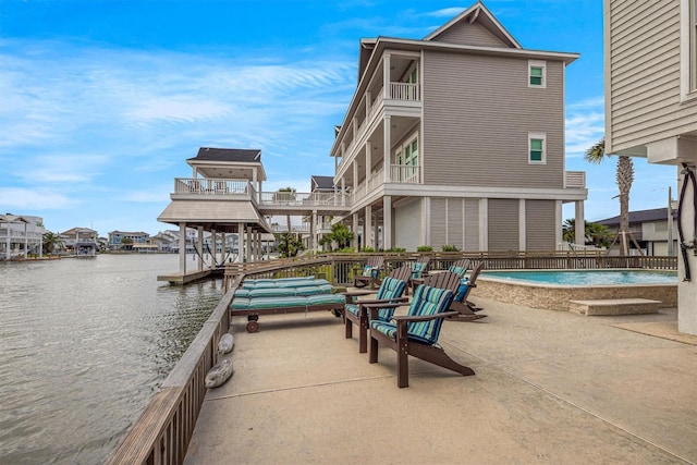 exterior space with a patio area, a water view, and a balcony