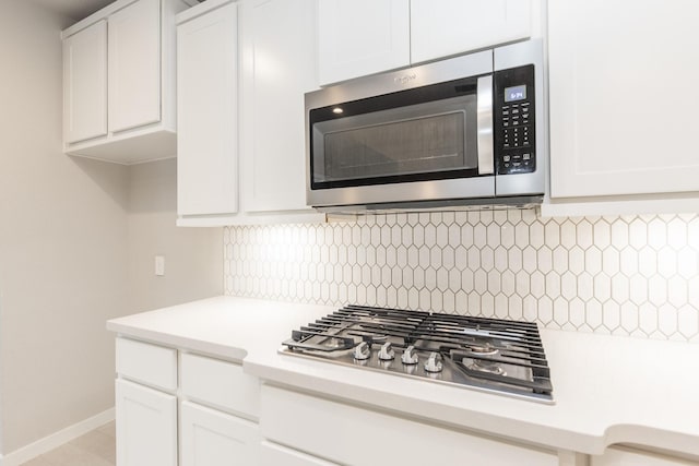 kitchen featuring white cabinetry, backsplash, and appliances with stainless steel finishes