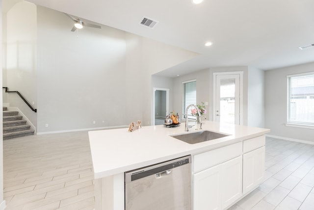 kitchen with dishwasher, sink, an island with sink, light hardwood / wood-style floors, and white cabinets