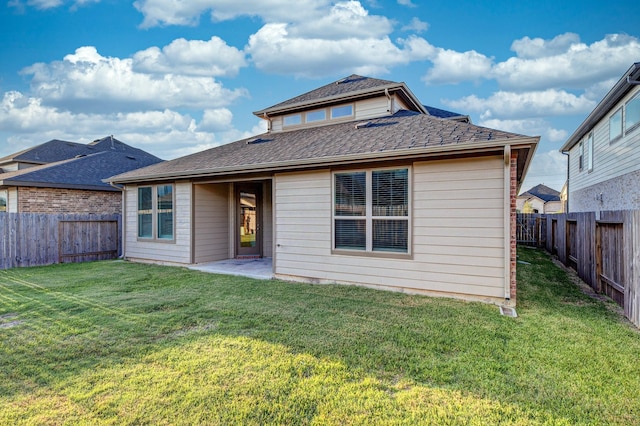 rear view of house featuring a yard and a patio