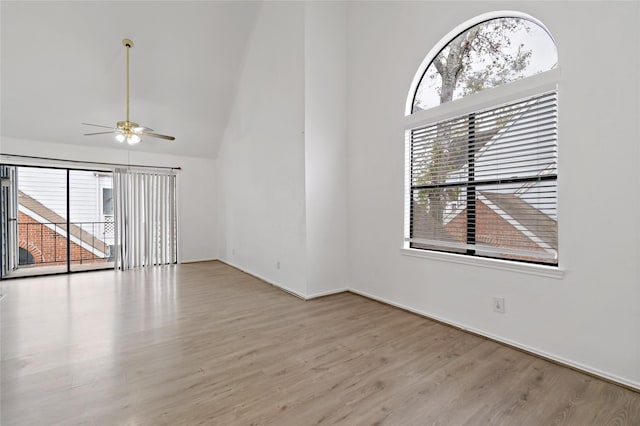 unfurnished living room featuring ceiling fan, high vaulted ceiling, light hardwood / wood-style floors, and a wealth of natural light