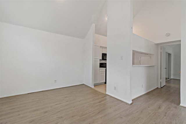 unfurnished living room with high vaulted ceiling and light wood-type flooring