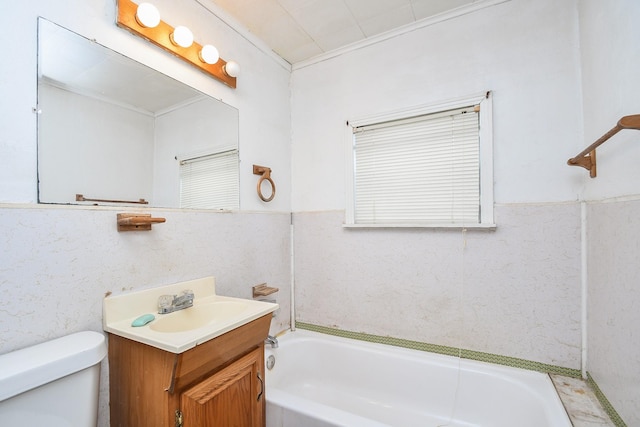 bathroom with ornamental molding, vanity, toilet, and a bathing tub