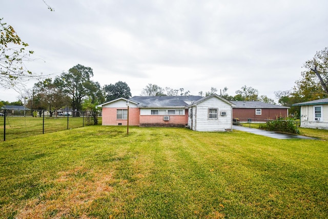 rear view of property featuring cooling unit and a yard