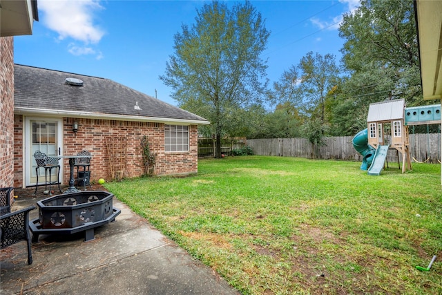 view of yard featuring a playground, a patio area, and a fire pit