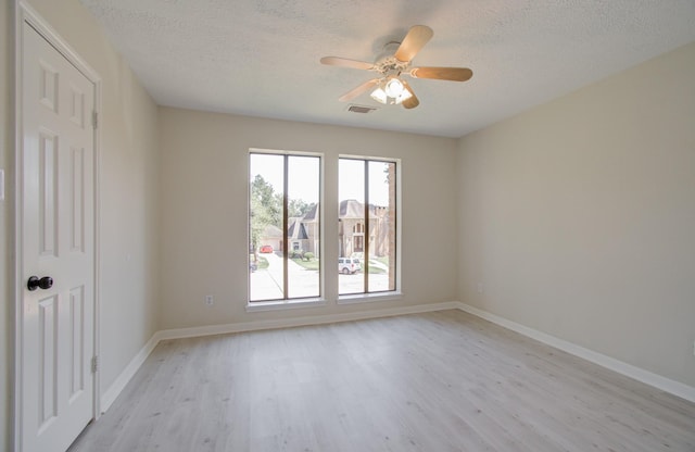 spare room featuring ceiling fan, light hardwood / wood-style floors, and a textured ceiling