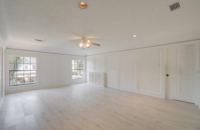 unfurnished living room with ceiling fan, a healthy amount of sunlight, and light wood-type flooring