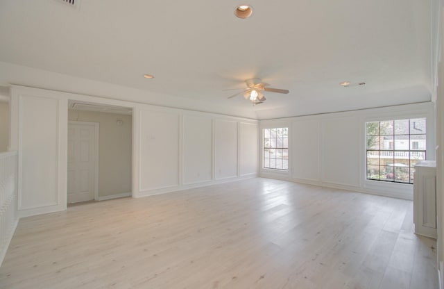 empty room with ceiling fan and light hardwood / wood-style flooring