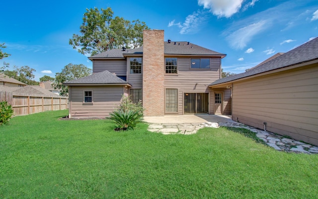 rear view of property featuring a lawn and a patio area