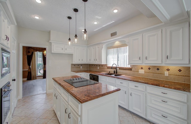 kitchen featuring sink, a kitchen island, black appliances, and a textured ceiling