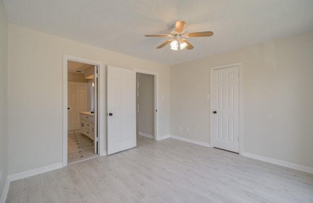 unfurnished bedroom featuring connected bathroom, ceiling fan, a textured ceiling, and light wood-type flooring