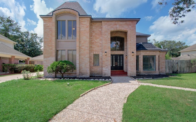 view of front of home with french doors and a front lawn