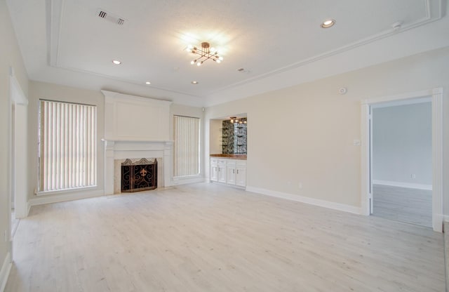 unfurnished living room featuring a notable chandelier and light hardwood / wood-style flooring