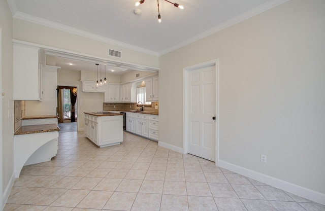 kitchen featuring light tile patterned floors, white cabinetry, hanging light fixtures, and crown molding