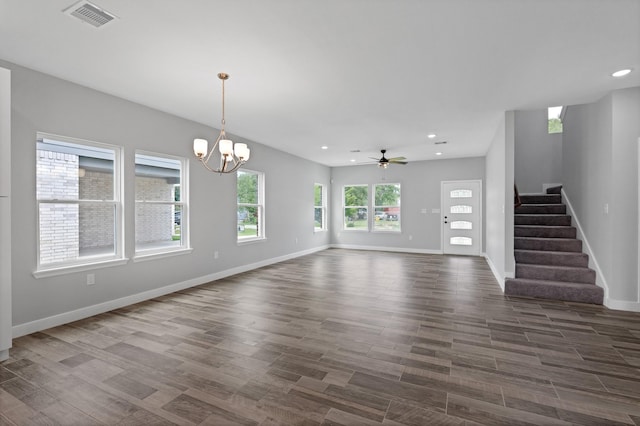 unfurnished living room featuring dark wood-type flooring and ceiling fan with notable chandelier