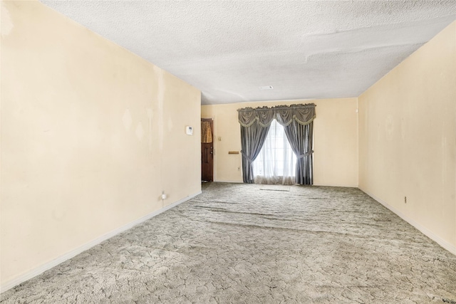 unfurnished room with carpet floors and a textured ceiling