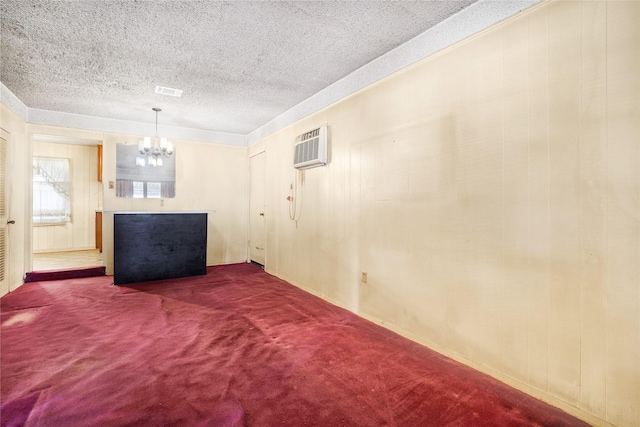 basement featuring a wall mounted air conditioner, carpet floors, and a notable chandelier