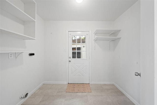 laundry room with electric dryer hookup and light tile patterned flooring