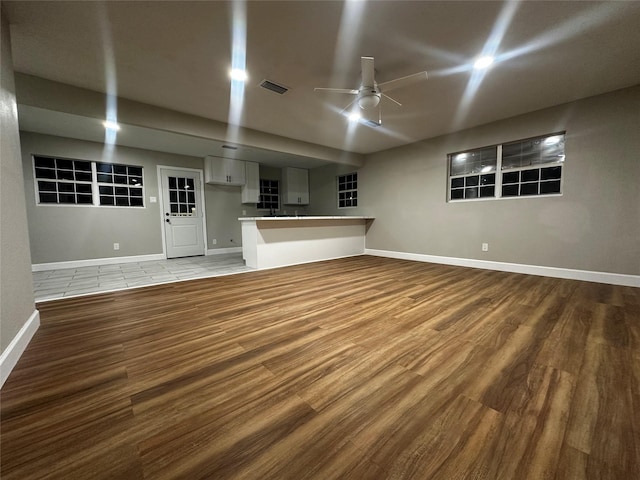 unfurnished living room featuring ceiling fan and hardwood / wood-style floors