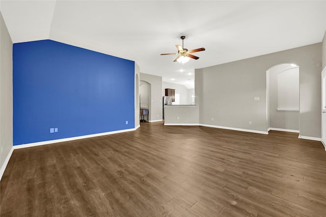 unfurnished living room with ceiling fan, dark hardwood / wood-style flooring, and vaulted ceiling