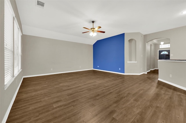 unfurnished living room featuring ceiling fan, dark hardwood / wood-style flooring, and vaulted ceiling