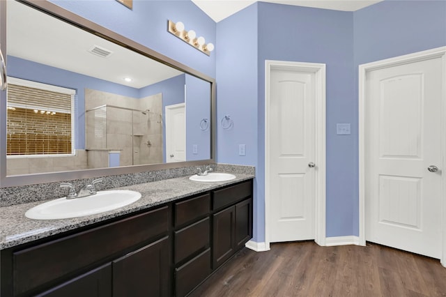 bathroom with hardwood / wood-style floors, vanity, and walk in shower