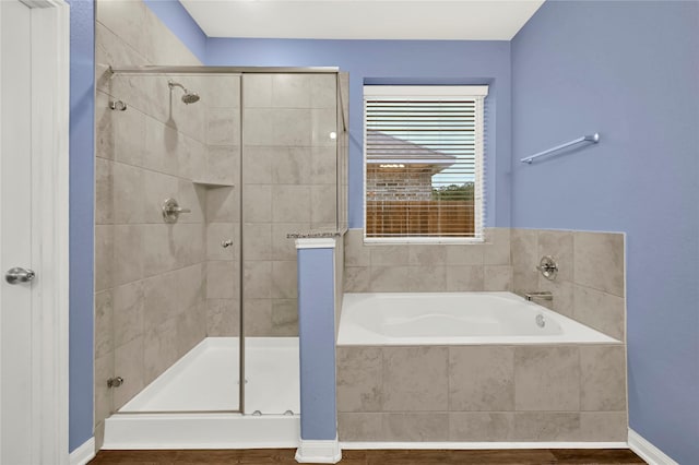 bathroom with wood-type flooring and shower with separate bathtub