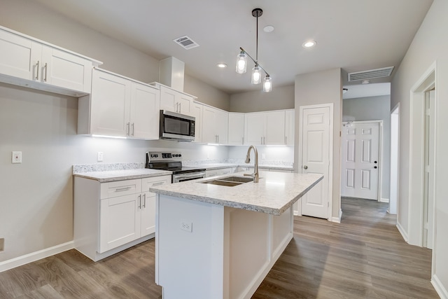 kitchen featuring white cabinets, pendant lighting, a center island with sink, and stainless steel appliances