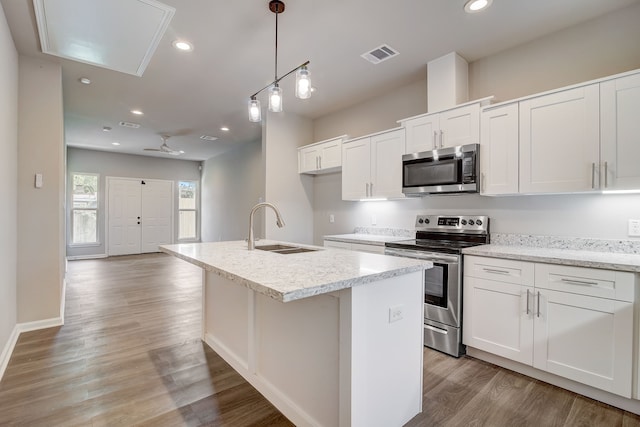 kitchen with white cabinetry, a kitchen island with sink, sink, and stainless steel appliances